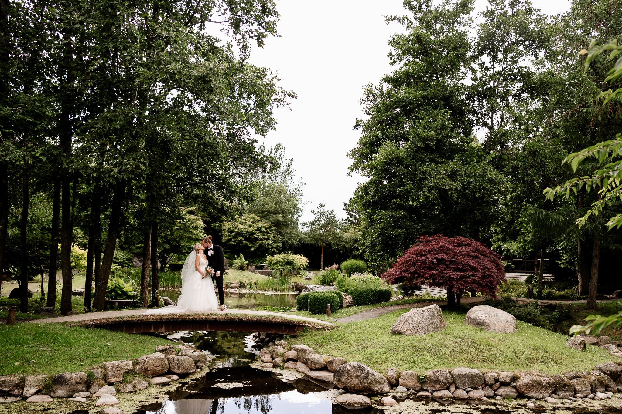 A wedding couple standing on a bridge in the beautiful nature in Park13 the Danish Japanese garden